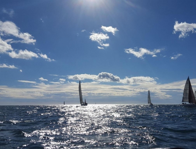 Velero al fondo bajo el sol